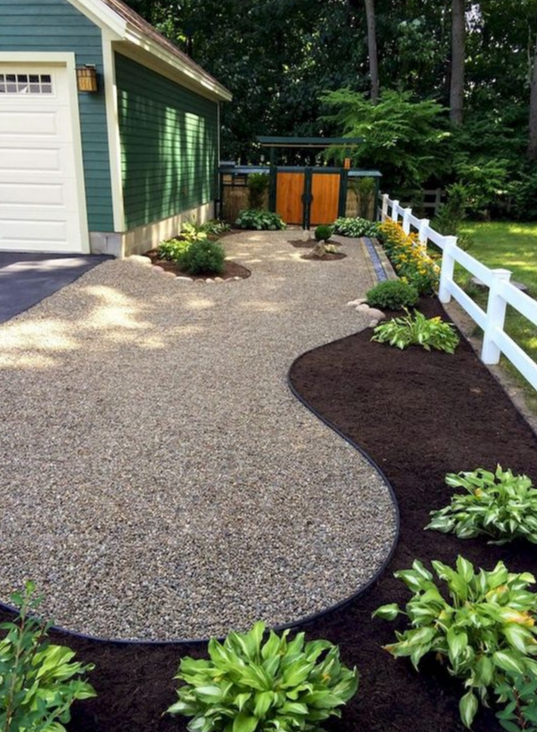 Driveway landscaping with mulched beds and hostas