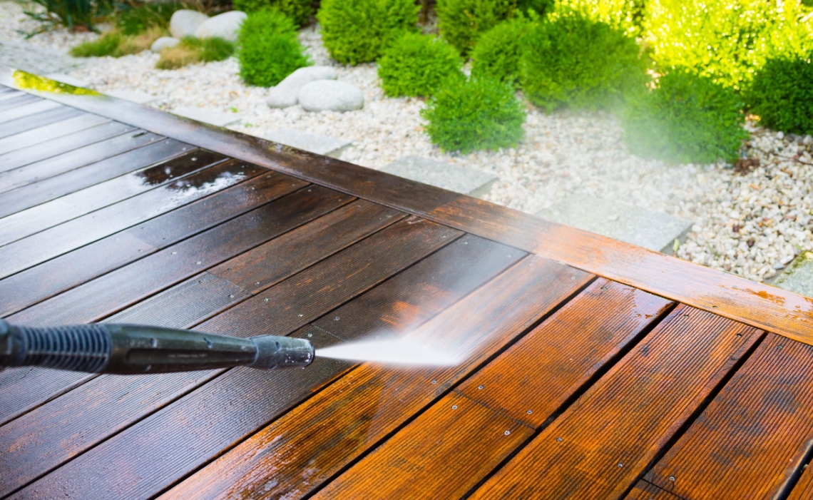 Deck restoration pressure washing with beautiful landscaping showcasing complete property care