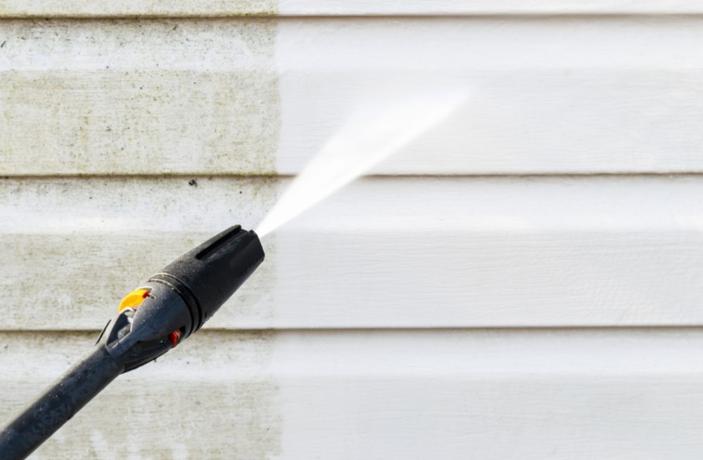 House siding pressure washing removing dirt and grime from white exterior